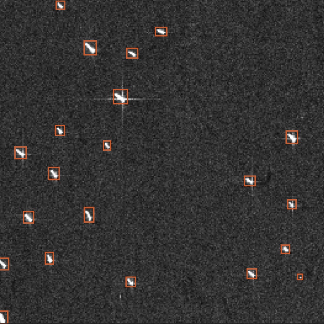 Greyscale radar image of open sea with ships as bright marks, each enclosed in an orange detection box.